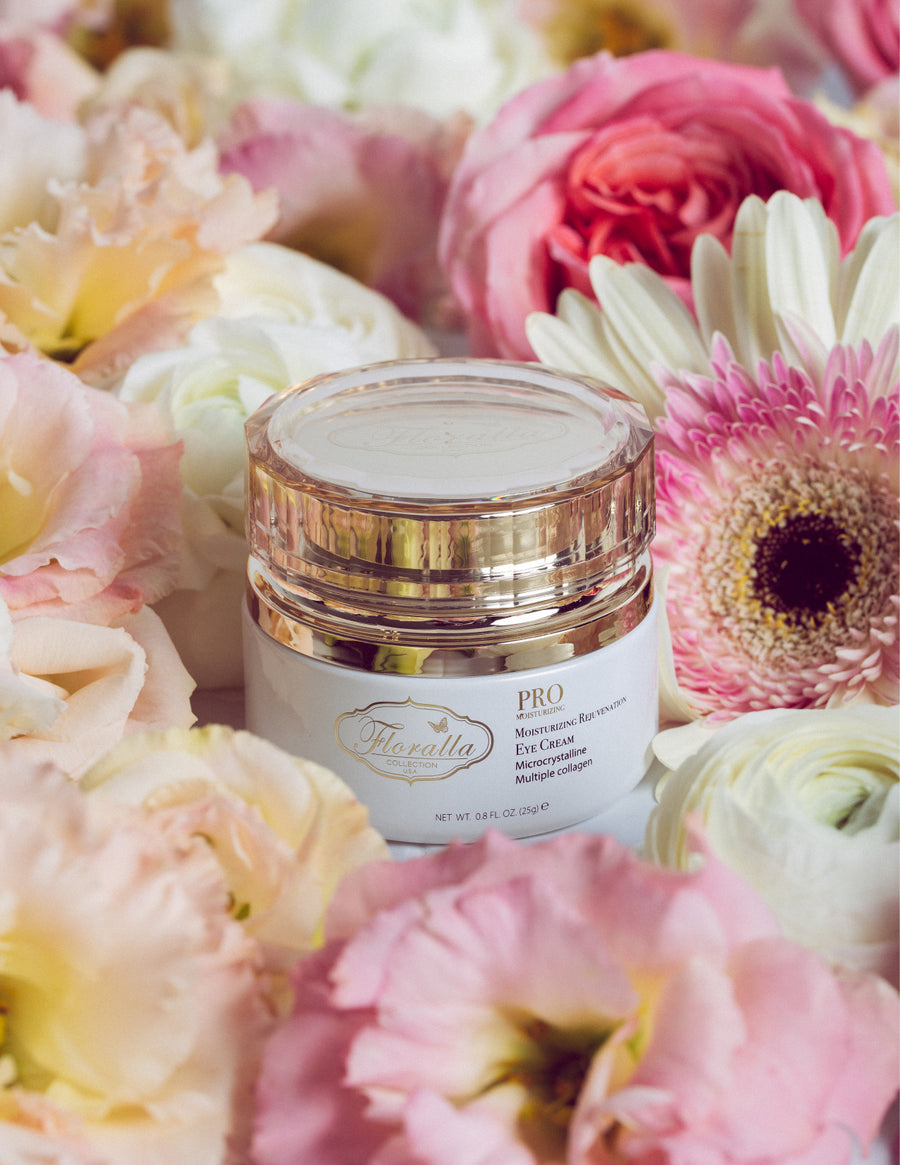 Floralla PRO Moisturizing Rejuvenation Eye Cream jar with microcrystalline and collagen formula, displayed among pink, white, and peach flowers, representing luxury skincare for anti-aging and hydration.