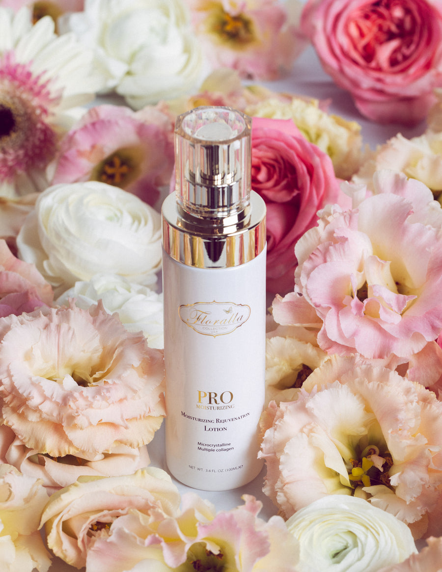 Floralla Pro Moisturizing Rejuvenation Lotion, in white bottle with gold accents, surrounded by pink and white roses.