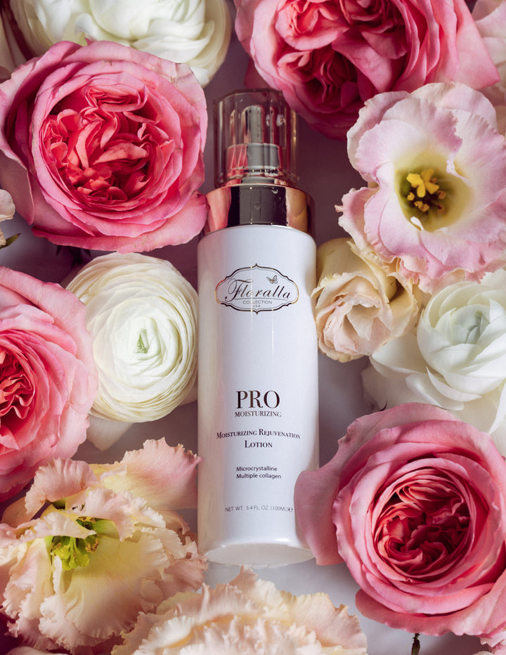 Floralla Pro Moisturizing Rejuvenation Lotion, in white bottle with gold accents, surrounded by pink and white roses.