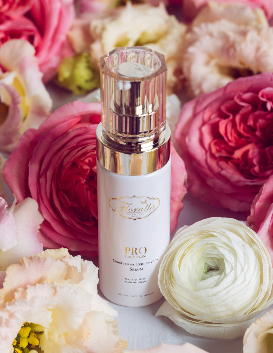 Floralla Pro Moisturizing Rejuvenation Serum, in white bottle with gold accents, surrounded by pink and white roses.