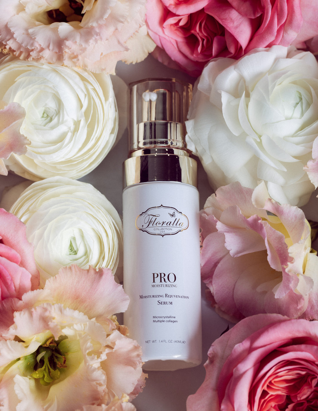 Floralla Pro Moisturizing Rejuvenation Serum, in white bottle with gold accents, surrounded by pink and white roses.