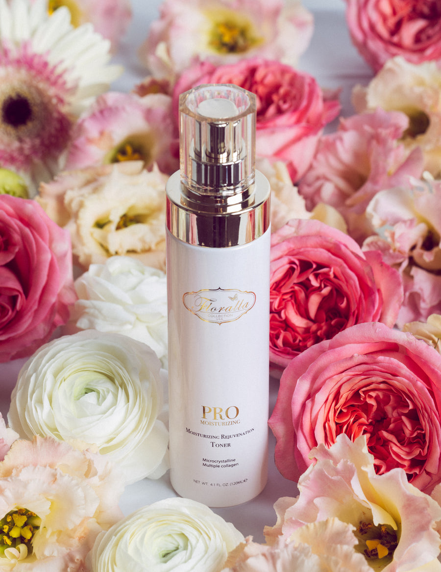 Floralla Pro Moisturizing Rejuvenation Toner, in white bottle with gold accents, surrounded by pink and white roses.