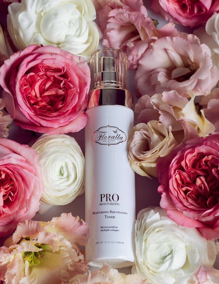 Floralla Pro Moisturizing Rejuvenation Toner, in white bottle with gold accents, surrounded by pink and white roses.
